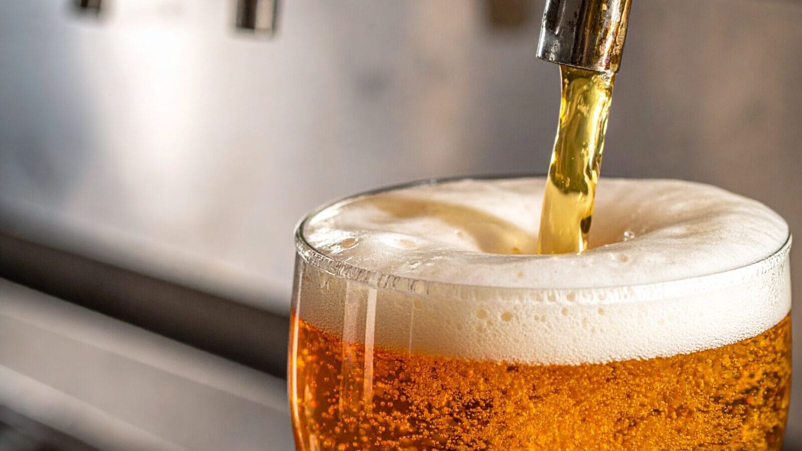 Foto mit Nahaufnahme wie ein Bier gezapft wird mit Schaum